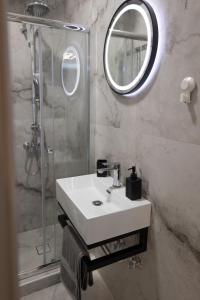a bathroom with a sink and a shower with a mirror at Elario studio in Larisa +31 photos