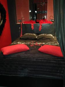 Un dormitorio con una cama con almohadas rojas. en La Cage Village Naturiste, en Cap d'Agde