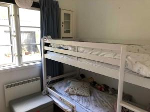 een wit stapelbed in een kamer met een raam bij Unique, Artistic House With Fjord View in Holbæk