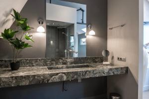 a bathroom with a sink and a mirror at Luxe Suite, Near Station & Free Wifi in Oss