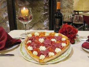 a pizza on a table with a candle and wine glasses at Corte dei Monaci in Canicattì +8 photos