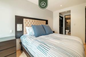 a bedroom with a large bed with blue pillows at 2 BR Condo in Polanco with Pool and Gym in Mexico City