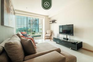 a living room with a couch and a flat screen tv at 2 BR Condo in Polanco with Pool and Gym in Mexico City