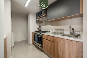 a small kitchen with a stove and a sink at 2 BR Condo in Polanco with Pool and Gym in Mexico City