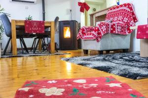 a living room with red blankets on two chairs and a fireplace at Guest House Lejla in Travnik