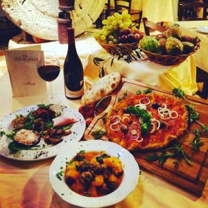 una tavola con piatti di cibo e un bicchiere di vino di Corte dei Monaci a Canicattì