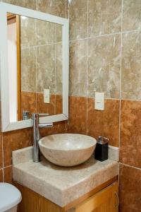 a bathroom with a sink and a mirror at Loft precioso con cocineta parking SmartTV in San Cristóbal de Las Casas