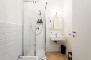 un bagno bianco con doccia e lavandino di Giardino a Milano - Elegante Appartamento a Milano Altre 10 foto