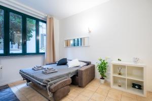 una camera con letto, divano e finestre di Giardino a Milano - Elegante Appartamento a Milano