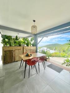 a dining room with a table and chairs with a view at Lodge douceur tropicale Sainte-Luce vue mer in Sainte-Luce