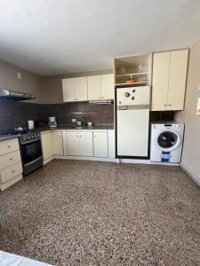 a kitchen with a white refrigerator and a washer at Beach House in Santa Teresita