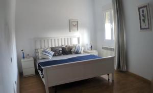 a bedroom with a white bed with blue sheets and pillows at Vivienda Rural Paraje El Sotillo in Carchel +24 photos