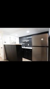 kuchnia z lodówką ze stali nierdzewnej i czarnymi szafkami w obiekcie Modern and luxury 3500 sq feet house jetted tub over 10000 sq feet lot w mieście Edmonton