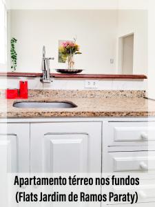 a white kitchen with a sink and a counter at Flats Jardim de Ramos em Paraty, RJ in Paraty +103 photos