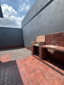 ein Badezimmer mit einem Waschbecken an einer Backsteinwand in der Unterkunft El Encanto Jujuy 1 in San Salvador de Jujuy + 4 Fotos