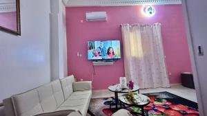 a living room with a couch and a tv on a wall at Mini Studio de Luxe in Thiès +12 photos
