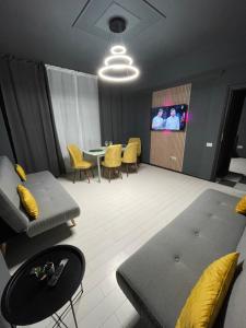 a living room with a couch and a table with yellow chairs at Militari Residence Luxury 23 in Roşu