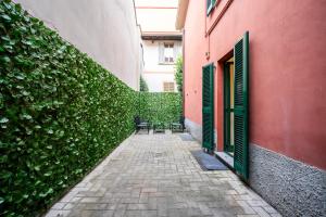 un vicolo con due sedie e un muro con piante di Giardino a Milano - Elegante Appartamento a Milano