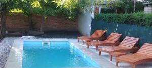 a group of chairs sitting next to a swimming pool at Cabañas Don Pocho in Villa Cura Brochero