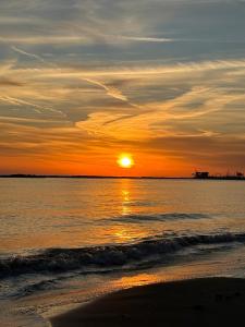 a sunset on the beach with the sun setting at Essentia Rooms & Relax in Vasto