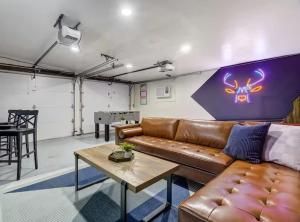 a living room with a leather couch and a table at Pikes Breeze - Premier Locale Workcation Hub in Colorado Springs