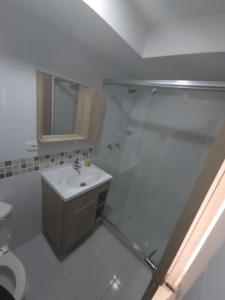 a white bathroom with a shower and a sink at Paz y Comodidad en Ricaurte, a 10 Min de Girardot in Ricaurte
