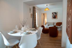 ein weißes Esszimmer mit einem weißen Tisch und Stühlen in der Unterkunft Dijon hypercentre - Loge Buffon in Dijon
