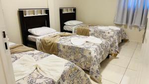 a group of three beds in a room at Apto Lindo e Amplo, 150m Praia in Cabedelo