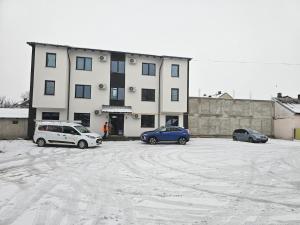 two cars parked in a parking lot in front of a building at visitor's house 1 in Rădăuţi