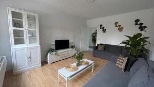 a living room with a couch and a tv at La Ferme du Château - Superior Suite in Fontaine-lʼÉvêque