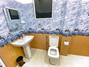 a bathroom with a sink and a toilet and clouds at Shalom Resorts Yala in Tissamaharama +24 photos