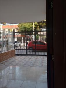 a gate with a red car in a parking lot at Hermosa Casa en Santa Marta in Santa Marta