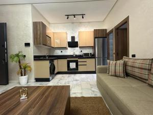 a living room with a couch and a kitchen at Cozy appartement luxueux in Mohammedia