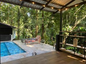 a patio with a pool and a table and a couch at Finca Ardilla Jungle Lodge in Cocles
