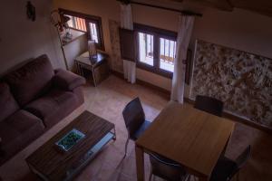 uma sala de estar com um sofá e uma mesa em Apartamentos Casa La Cuca em Alfambra