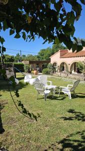 a group of white chairs sitting in the grass at Mirasoles Hotel in Mina Clavero +34 photos