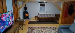 a living room with a tv and a table and a fireplace at Csergő Kulcsosház in Senetea