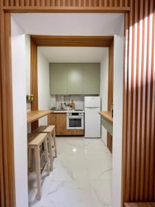 Una cocina con gabinetes verdes y un refrigerador blanco. en Ella Lux Apartment, en Skopje