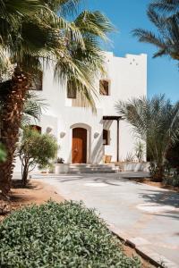una casa blanca con palmeras delante en Luxury villa west golf, en Hurghada 14 fotos más
