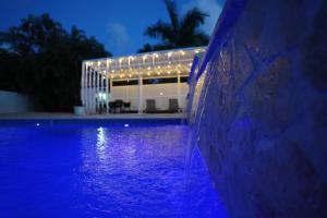 a swimming pool at night with a building in the background at Beachtown Luxury Villas Apt 204 in Aguacate