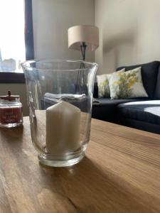 a glass vase with a candle on a table at Apartamento Coqueto en El Pueyo, céntrico con WIFI in El Pueyo de Jaca +39 photos
