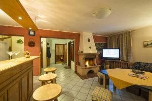 eine Küche mit einem Wohnzimmer mit einem Kamin in der Unterkunft Chata Pleso in Tatranska Strba