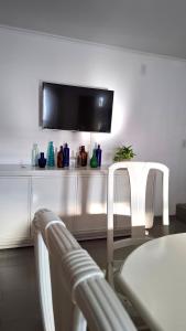 ein Esszimmer mit einem Tisch und 2 weißen Stühlen in der Unterkunft Departamento de dos plantas en zona centro San José, Entre Ríos in San José