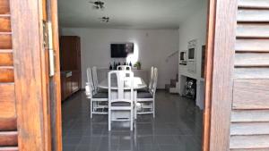 ein Esszimmer mit einem Tisch und weißen Stühlen in der Unterkunft Departamento de dos plantas en zona centro San José, Entre Ríos in San José