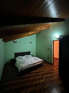 a bedroom with a bed in a room with green walls at Alex House in Borsa