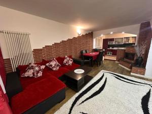 a living room with a red couch and a kitchen at Alex House in Borsa