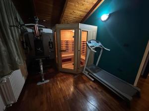 a gym with a treadmill in a room with a wooden floor at Alex House in Borsa