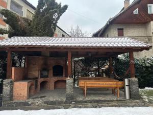 a wooden pavilion with a bench in front of a building at Alex House in Borsa