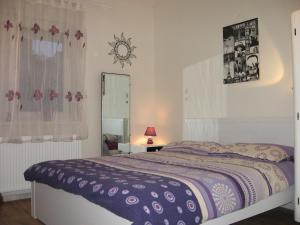 a bedroom with a bed with a purple blanket at Cute Apartment For You in Zagreb