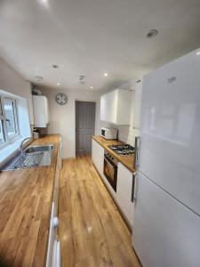 a kitchen with a white refrigerator and a wooden floor at Manor House walsall 3 in Walsall